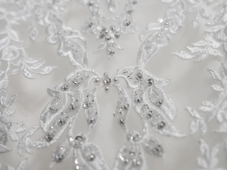 Close-up of silver beaded embroidery on white fabric