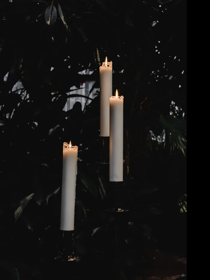 White candles lit in the dark