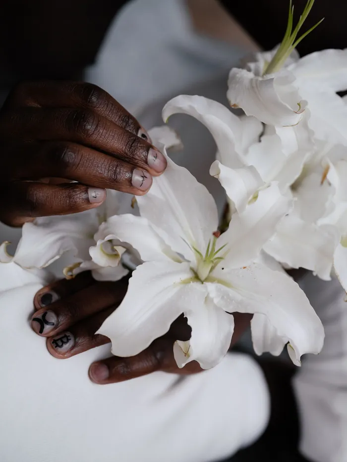 Hands holding white lilies
