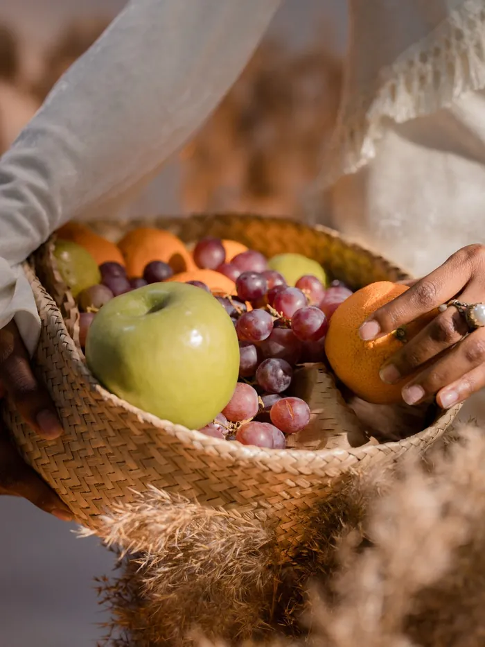 A worshipper in white holding a basket of fruit